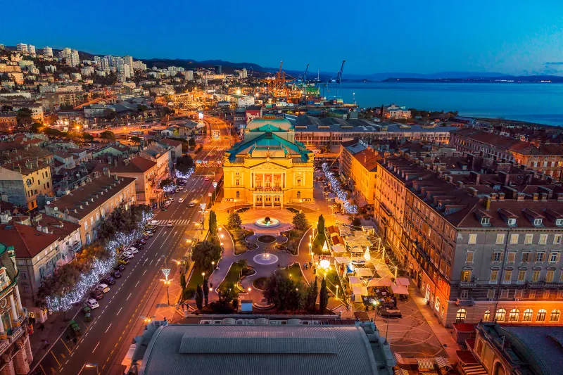 Appartementen Rijeka bieden een panoramisch uitzicht op de Korzo met het Kroatisch Nationaal Theater, de fontein en het met kerst versierde centrum aan de Adriatische Zeekust bij zonsondergang.