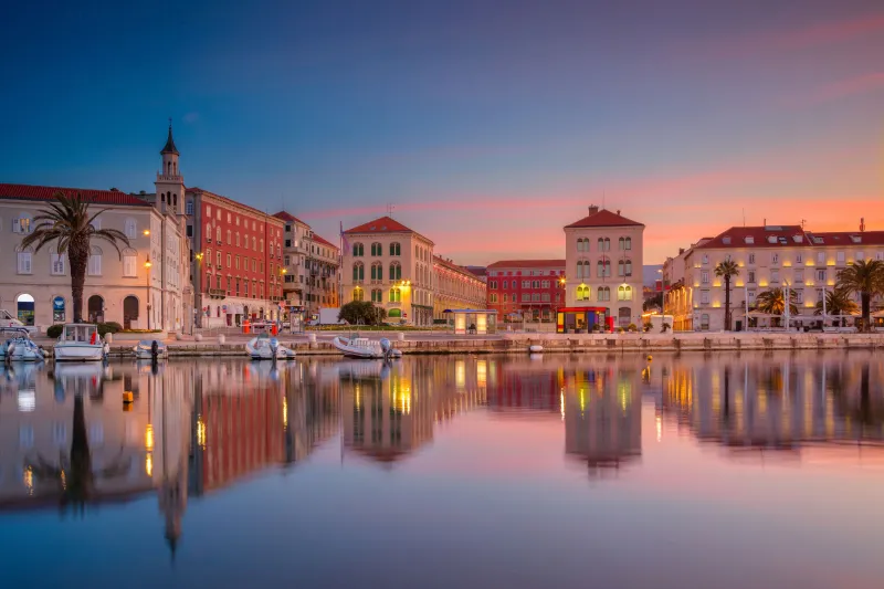 Apartmani Split – zalazak sunca nad splitskom Rivom, šarene palače i brodice odražavaju se u mirnom moru.
